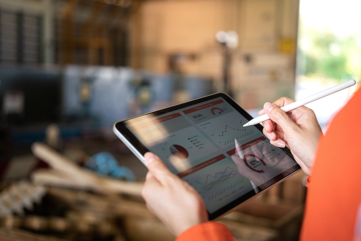 a person using a tablet to leverage the benefits of paperless manufacturing